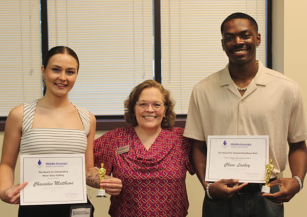 Chassidee Matthews (left) receives the Outstanding News Story Editing Award and Chase Lackey (right) receives the Outstanding News Reel Award from Dr. Cindy Montgomery, Assistant Professor of Media and Communication.